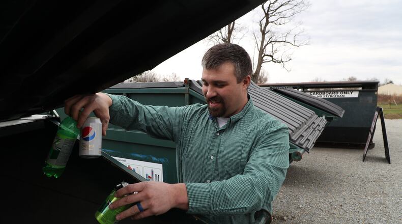 Brian Clem, a Green Township Trustee, puts recycling in one of the new recycling dumpsters at the new Clark County Solid Waste District recycling station located behind the Pitchin Fire Station Tuesday. BILL LACKEY/STAFF