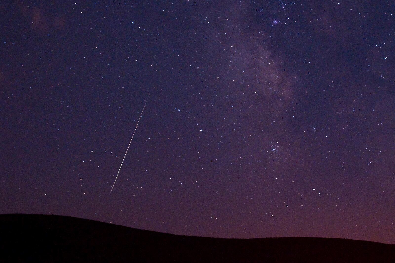 FILE - A Perseid meteor streaks across the sky during the Perseid meteor shower in Vinton, California, Aug. 11, 2009. (AP Photo/Kevin Clifford, File)