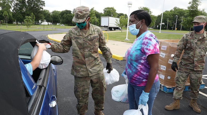 Leigh Stowers, along with Sgt. Raishan Magby, left, and SrA James Fulton of the National Guard, pass out food during the Summer Food Program at Fulton Elementary School in 2020. This year's Summer Food Program kicks off this week and will run through August. BILL LACKEY/STAFF