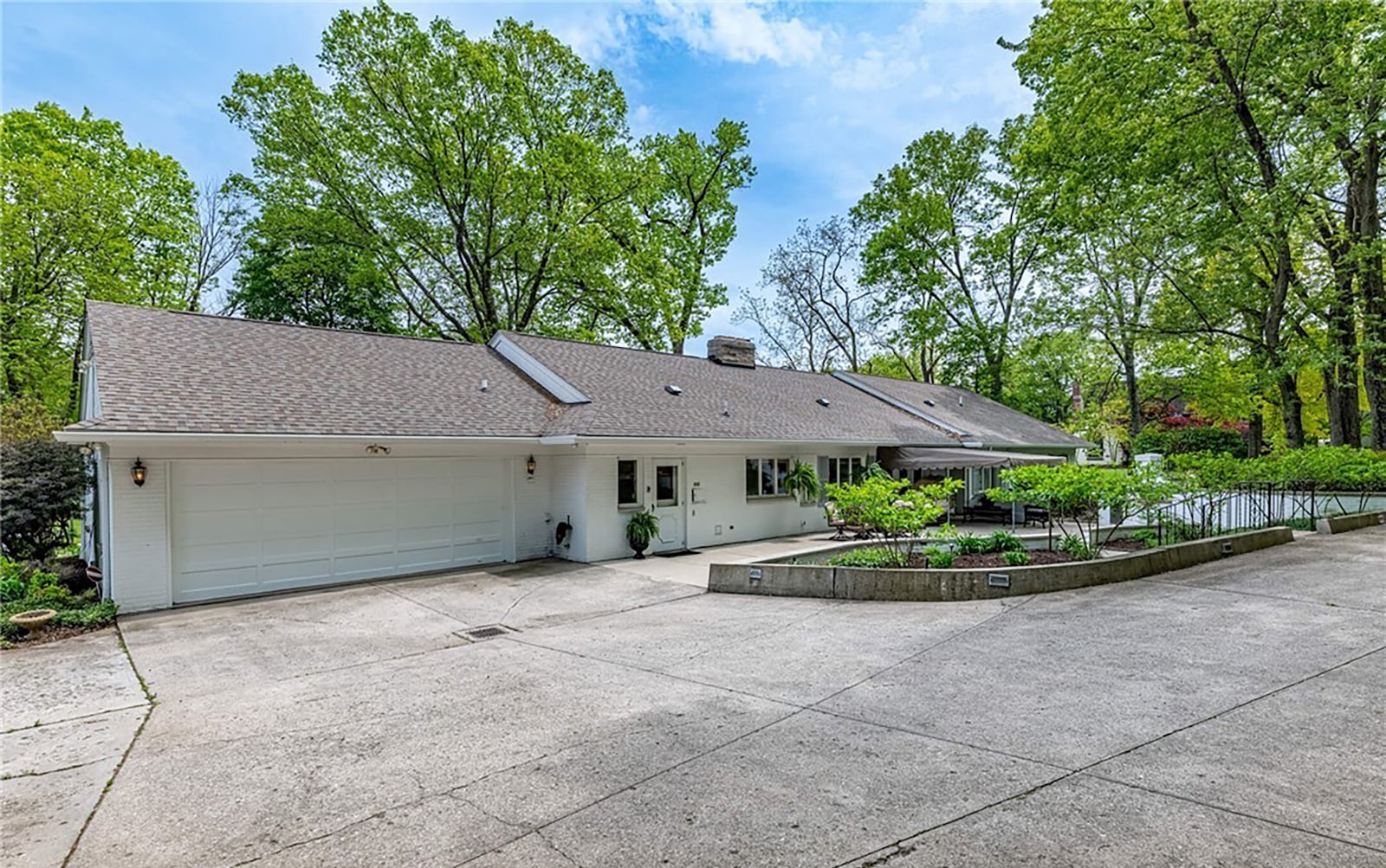 The rear has a four car tandem garage and an expansive concrete patio connected to the driveway. CONTRIBUTED