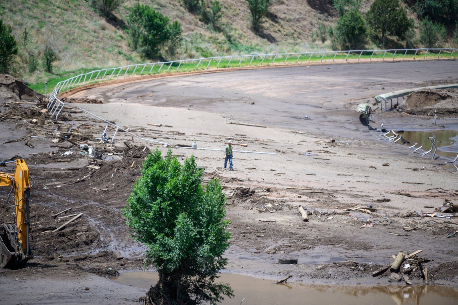 A man crosses the Ruidoso Downs Racetrack which was partially destroyed after the flood, Wednesday, July 9, 2025, in Ruidoso, N.M. (AP Photo/Roberto E. Rosales)