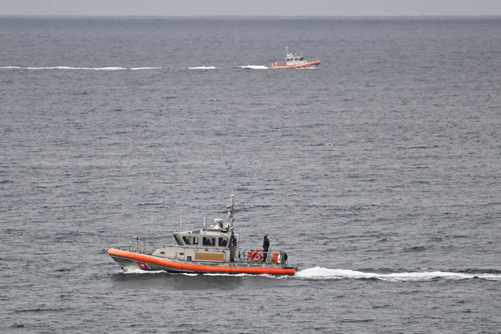 U.S Coast Guard boats look for survivors after a boat capsized in the surf Monday, May 5, 2025, at Torrey Pines State beach in San Diego, Calif. (AP Photo/Denis Poroy)