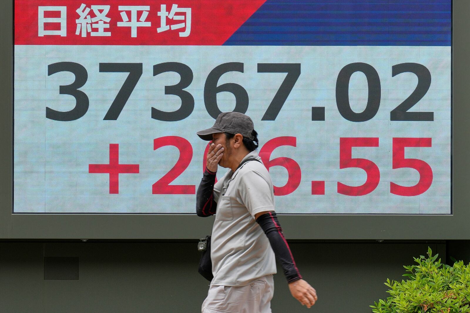 A person walks in front of an electronic stock board showing Japan's Nikkei index at a securities firm Monday, May 26, 2025, in Tokyo. (AP Photo/Eugene Hoshiko)
