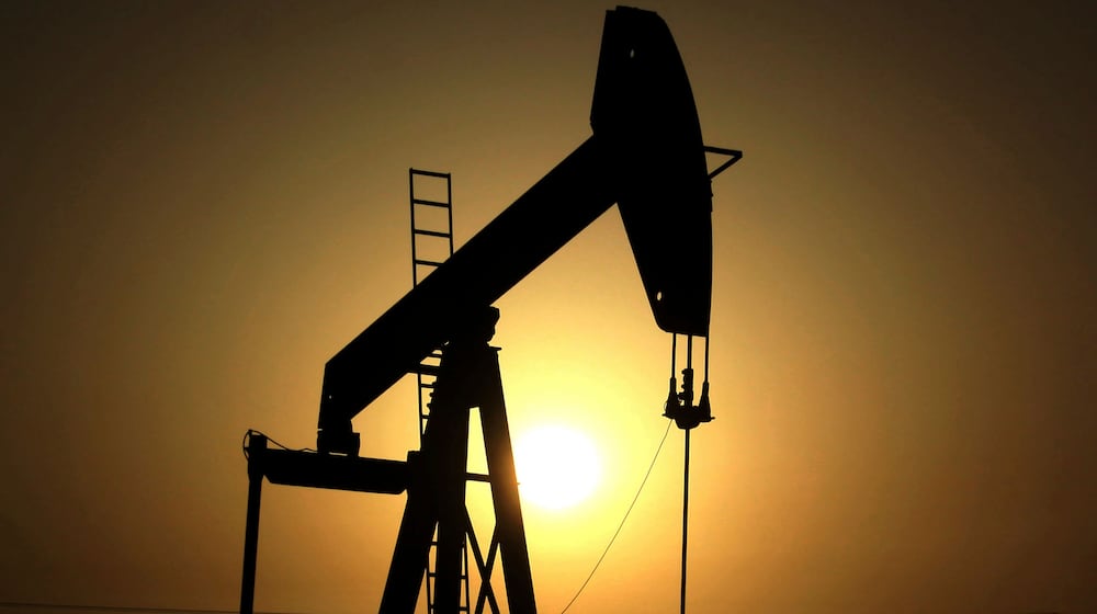 FILE- In this Wednesday, June 8, 2011 file photo, sun sets behind an oil pump in the desert oil fields of Sakhir, Bahrain. (AP Photo/Hasan Jamali, File)