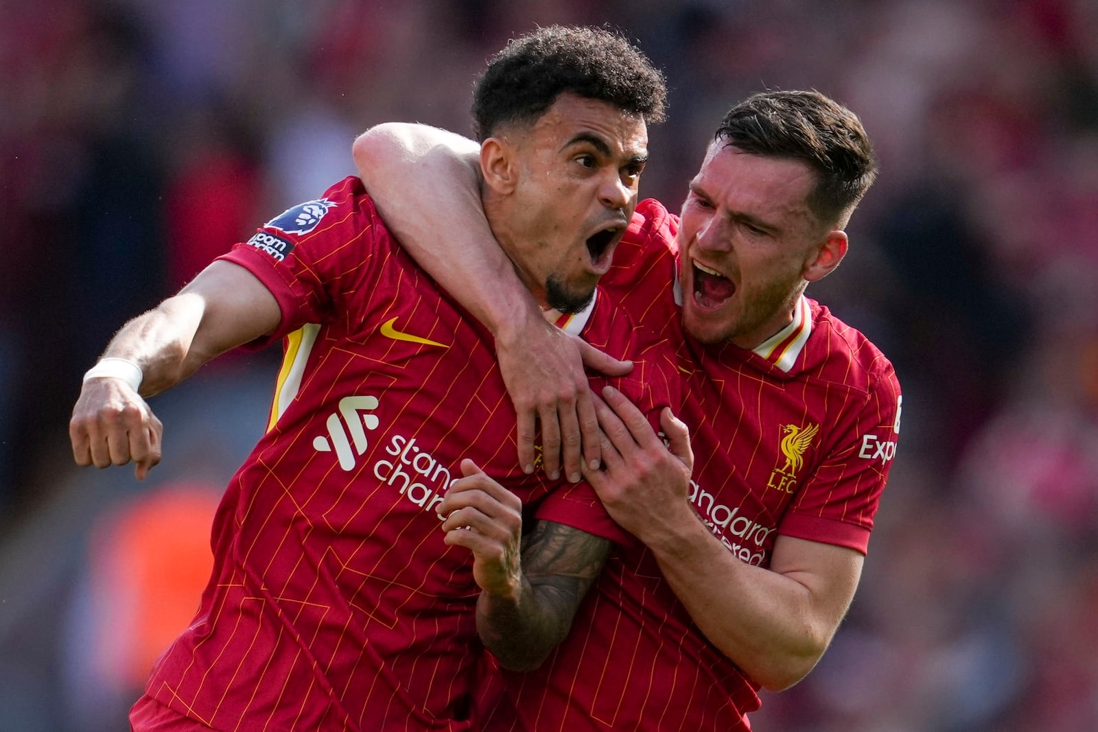 Liverpool's Luis Diaz, left, celebrates with Liverpool's Andrew Robertson after scoring his side's first goal during the English Premier League soccer match between Liverpool and Tottenham Hotspur at Anfield in Liverpool, England, Sunday, April 27, 2025. (AP Photo/Jon Super)