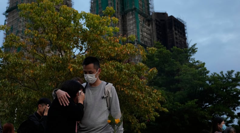 A man consoles a woman at the site of last weeks deadly fire at Wang Fuk Court, a residential estate in the Tai Po district of Hong Kong's New Territories on Tuesday, Dec. 2, 2025. (AP Photo/Ng Han Guan)