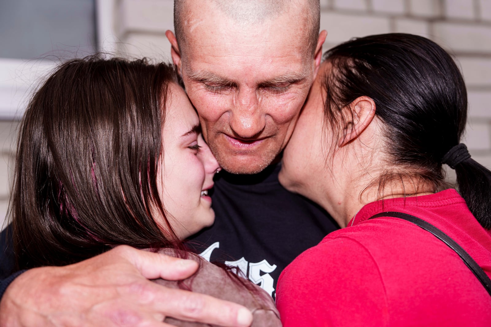 An Ukrainian soldier hugs with women after returning from captivity during a POWs exchange between Russia and Ukraine, in Chernyhiv region, Ukraine, Saturday, May 24, 2025. (AP Photo/Evgeniy Maloletka)