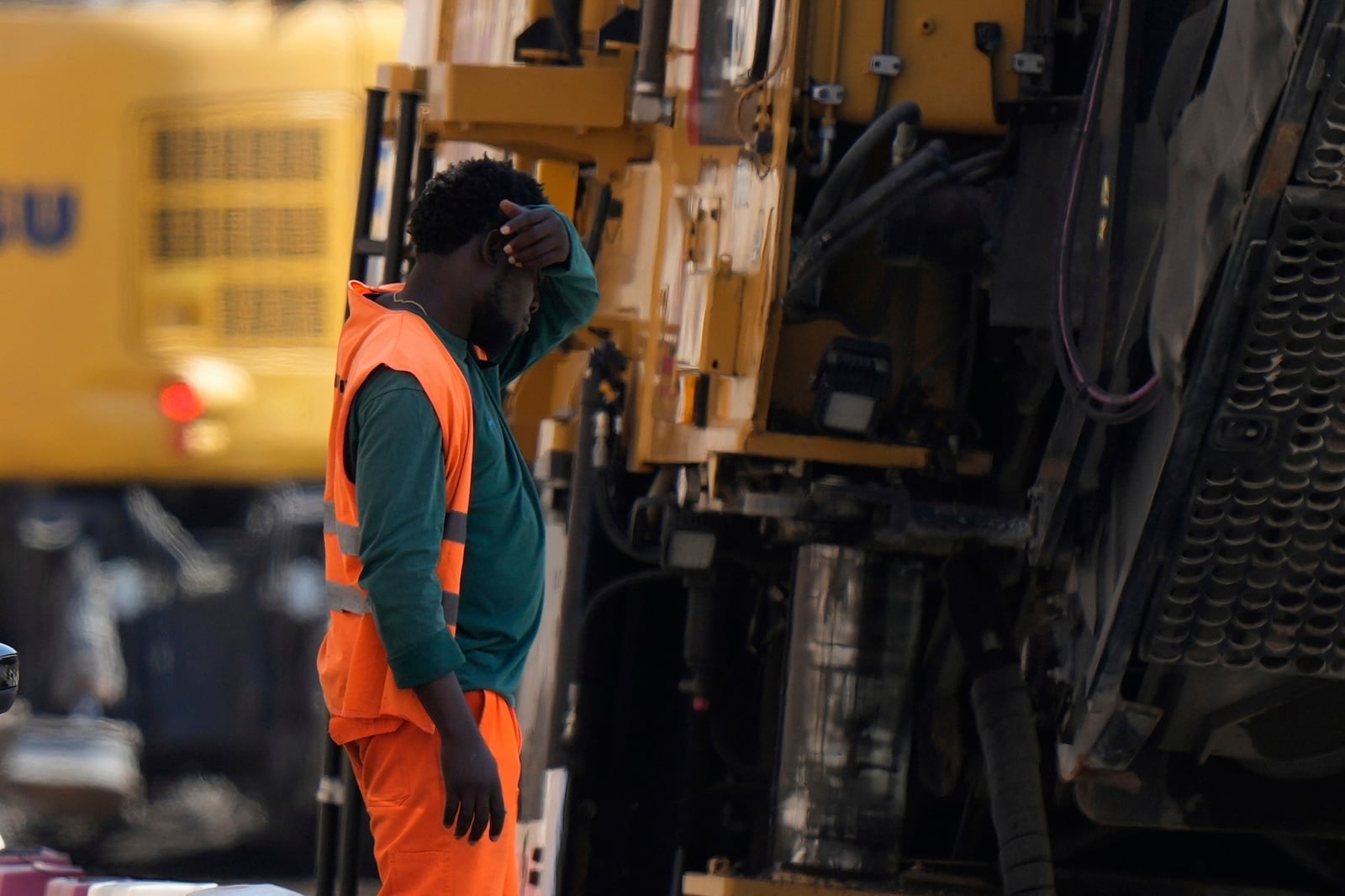 FILE - An employee takes a break as he works at a road construction site in Milan, Italy, July 1, 2025. (AP Photo/Luca Bruno, File)