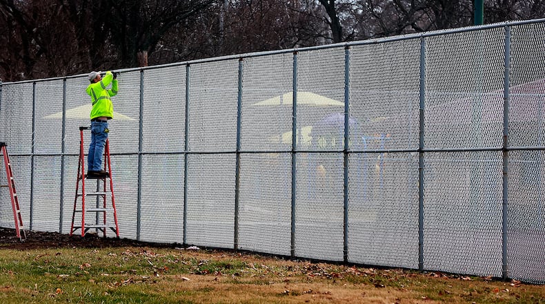 An employee of Hunt's Fencing works on the new fence aroung the Snyder Park tennis and pickleball courts Wednesday, Jan. 11, 2023. The courts have also been resurfaced for the growing pickleball population in Springfield. BILL LACKEY/STAFF