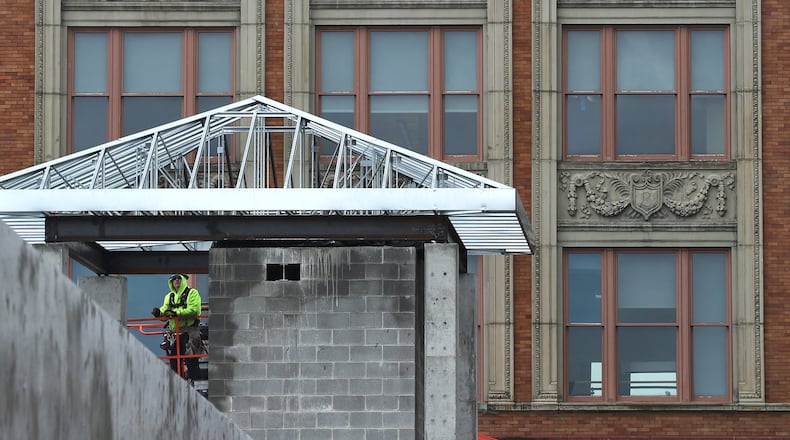 The Bushnell Building provides a background for a construction worker building a small roof on a corner of the new parking garage being built in downtown Springfield on Feb. 20. BILL LACKEY/STAFF