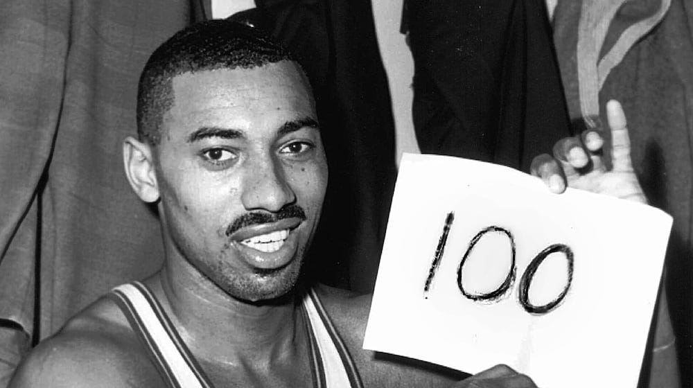 FILE - Philadelphia Warriors' Wilt Chamberlain holds a sign reading, "100," in the dressing room after he scored 100 points against the New York Knickerbockers, March 2, 1962, in Hershey, Pa. (AP Photo/Paul Vathis, File)