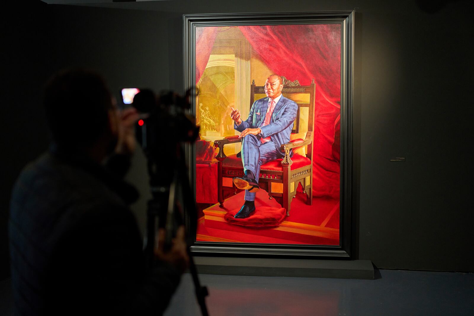 A member of the media films a portrait of Alpha Condé, former president of Guinea, during the opening of American painter Kehinde Wiley's exhibition A Maze of Power in Mohammed VI Museum of Modern and Contemporary Art, in Rabat, Tuesday, April 15, 2025. (AP Photo/Mosa'ab Elshamy)