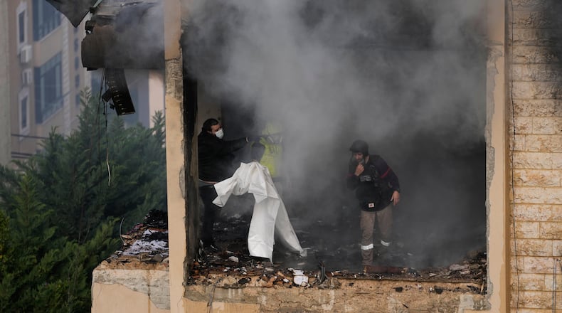 Rescue workers inspect an apartment damaged in an Israeli airstrike as thick smoke fills the building in the southern port city of Sidon, Lebanon, Saturday, March 14, 2026. (AP Photo/Mohammad Zaatari)