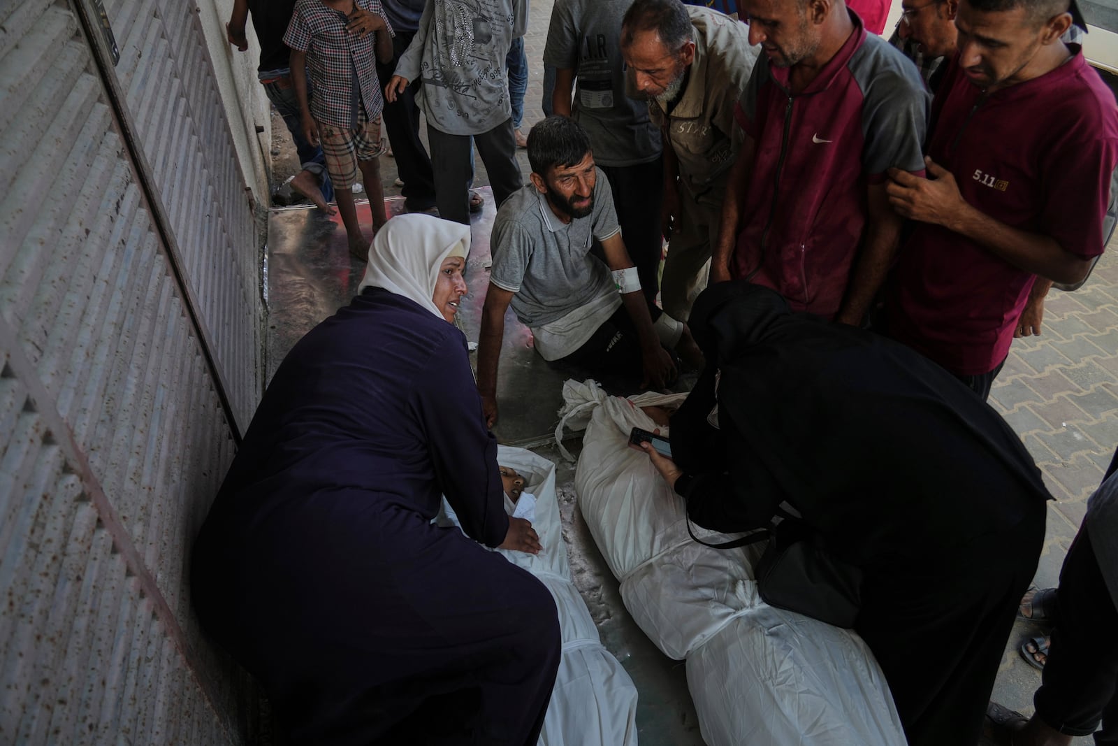 Mourners attend the funeral of their relatives killed in an Israeli bombardment, in Deir al-Balah, central Gaza Strip, Monday, July 21, 2025. (AP Photo/Abdel Kareem Hana)