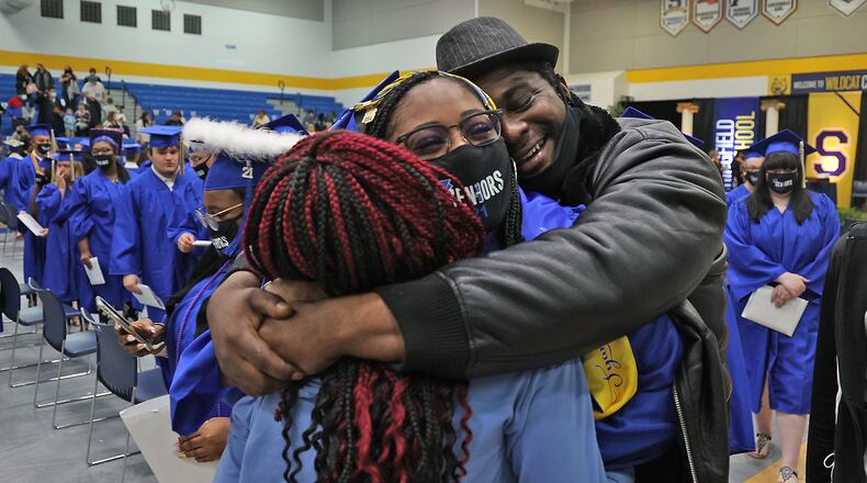 Springfield High School graduate Tyana Crossley is hugged by her father, Mitchell, and sister, Zayveana, after they rushed the floor as the graduates were marching out of the gymnasium Saturday. In an effort to keep crowds small, Springfield held three graduation ceremonies on Saturday. BILL LACKEY/STAFF