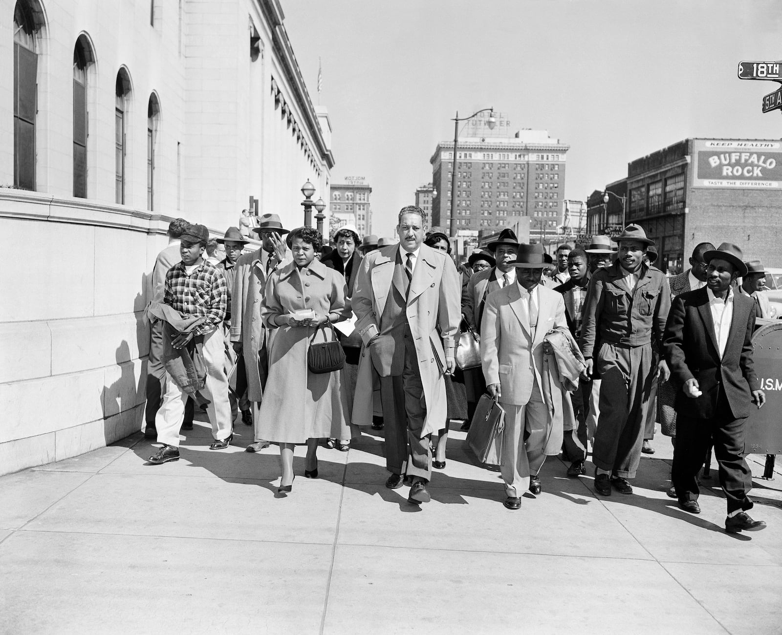 Autherine Lucy, left, front, 26-year-old student at the University of Alabama, arrives at U.S. District Court for the hearing of her petition for an order requiring the school to re-admit her to classes in Birmingham, Ala., Feb. 29, 1956. With Lucy are her legal team, Thurgood Marshall, tall man at center, and Arthur Shores, carrying coat at right. (AP Photo/Gene Herrick)