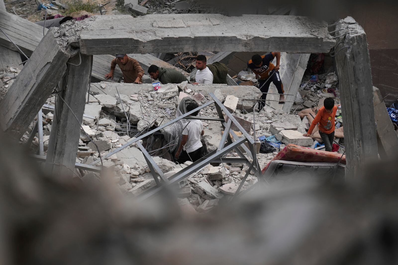 Palestinians inspect the damage caused by an Israeli army airstrike in Khan Younis, Gaza Strip, Tuesday, April 22, 2025. (AP Photo/Abdel Kareem Hana)