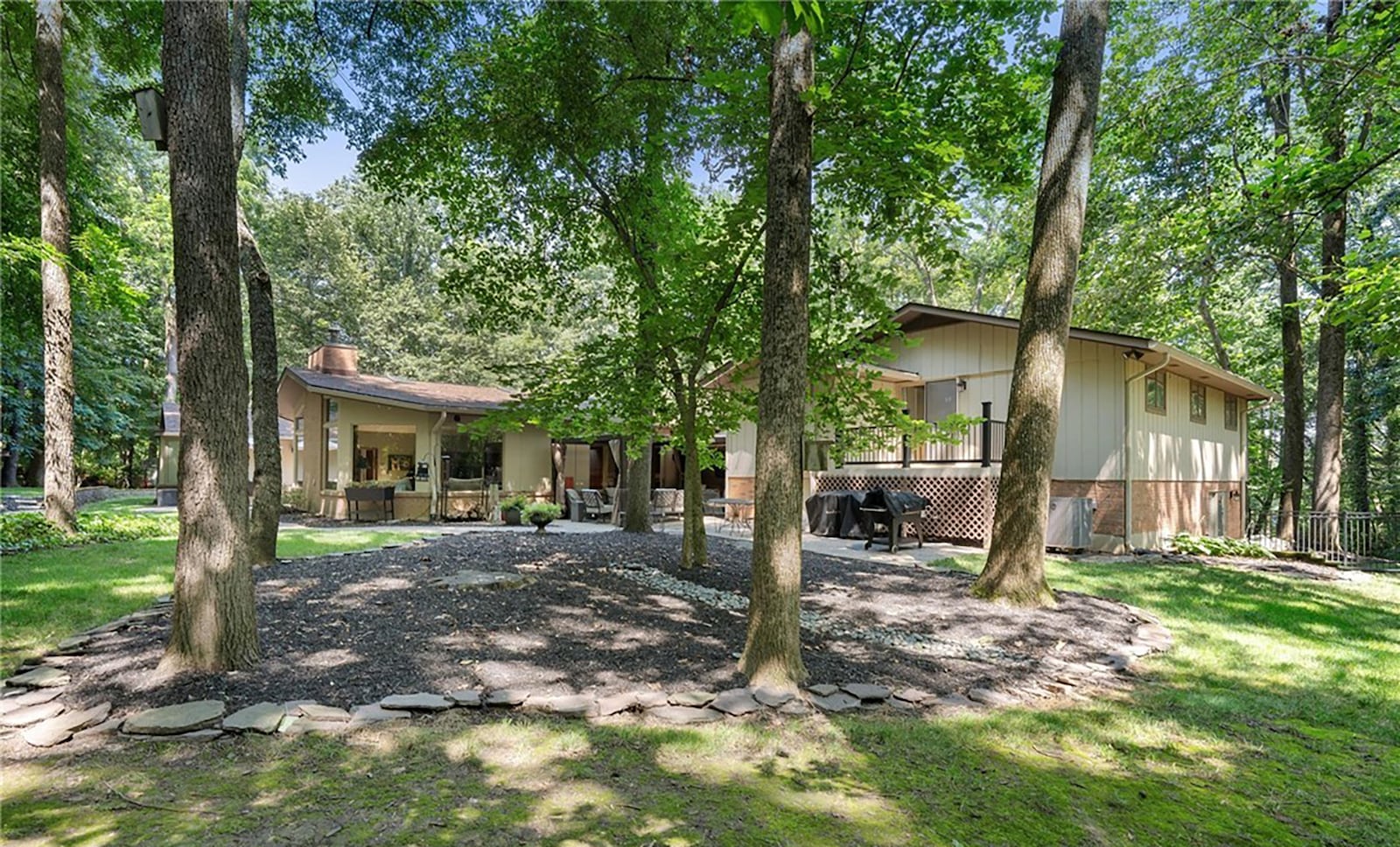 The exterior of the home features both paver and concrete patios and walkways as well as a wooded firepit area with a pathway. CONTRIBUTED