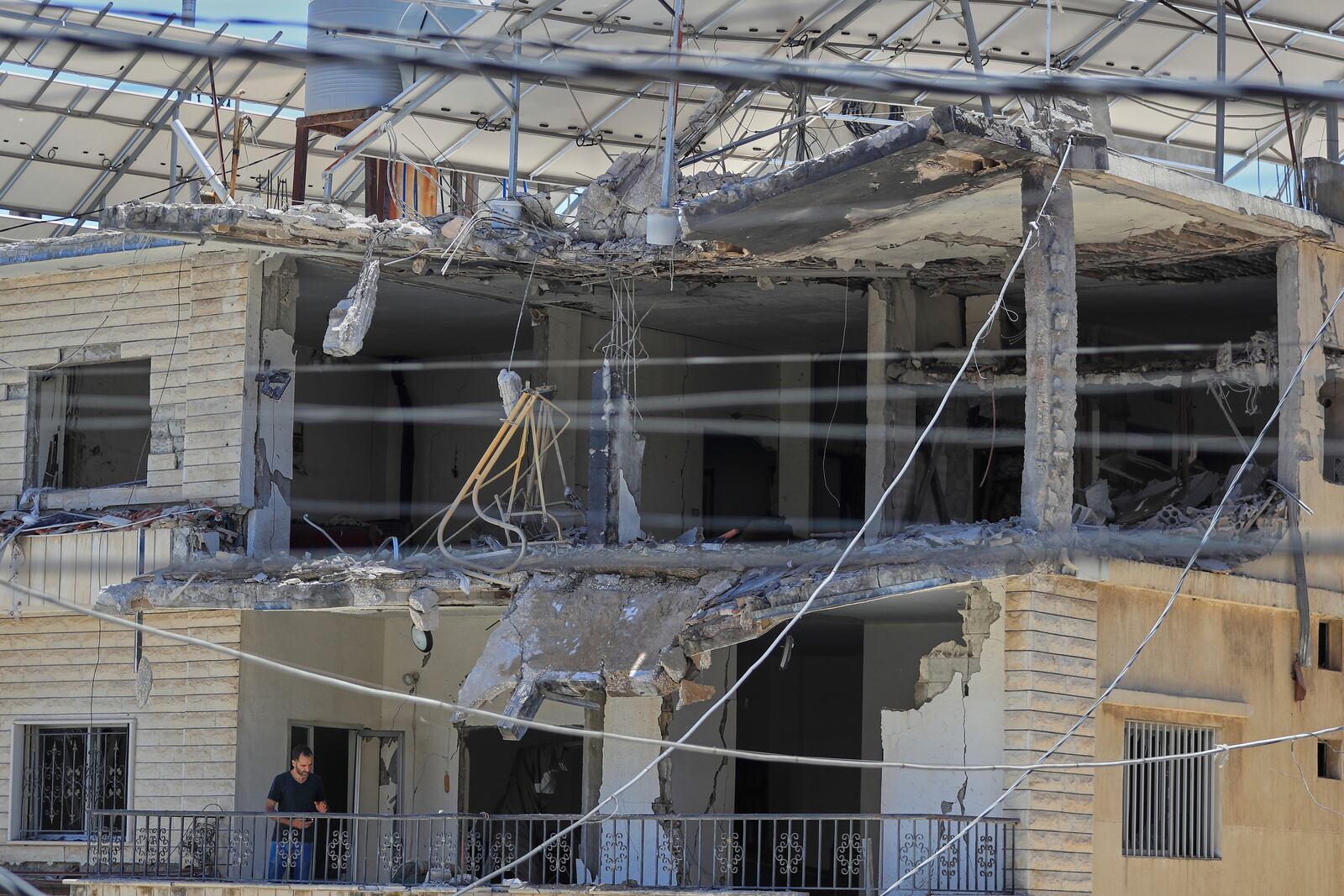 A man checks his destroyed house that was hit in an Israeli airstrike in Nabatieh town, south Lebanon, Friday, June 27, 2025. (AP Photo/Mohammed Zaatari)