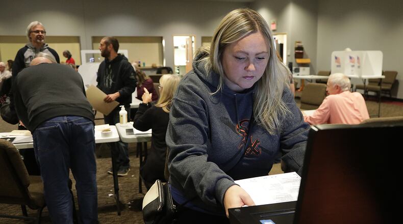 Cassie Gill puts her ballot into the voting machine at the election poll in the First Christian Church Tuesday. BILL LACKEY/STAFF