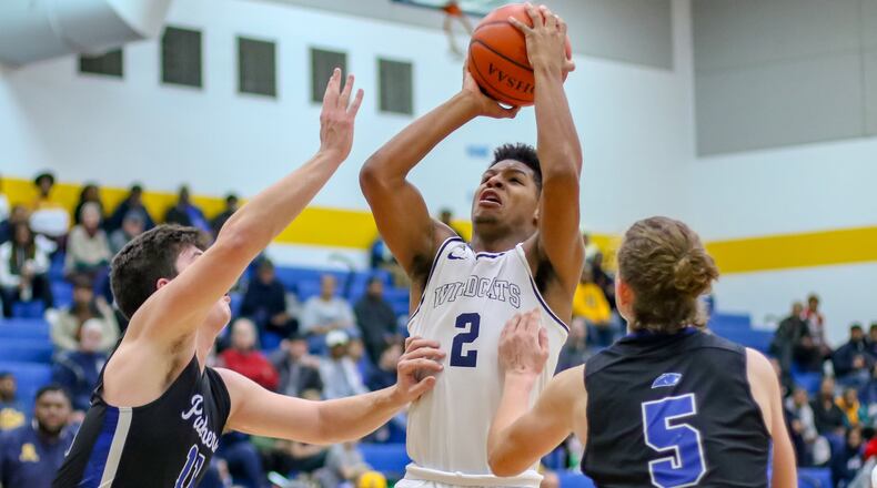 Springfield High School’s Jalan Minney shoots the ball in front of Springboro’s Landon Palmer and Sam Feldman during their game on Friday night in Springfield. The Wildcats won 60-50 in overtime. CONTRIBUTED PHOTO BY MICHAEL COOPER