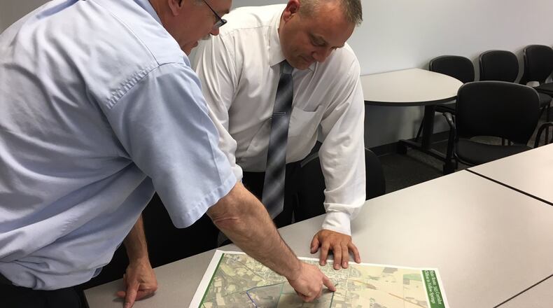 Ken LeBlanc (left), outgoing executive director of the Greene County Regional Planning and Coordinating Commission, goes over a zoning map of the county with the new executive director Devon Shoemaker on June 26, 2018. RICHARD WILSON/STAFF