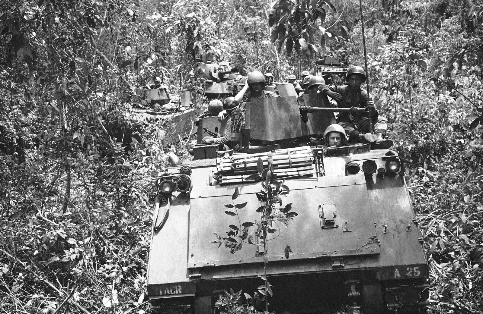 FILE- Armored personnel carriers with tank support move through dense underbrush with a payload of South Vietnamese infantrymen and U.S. cavalrymen during patrol through jungle 40 miles northeast of Saigon on June 5, 1969. (AP Photo/Rick Merron, File)