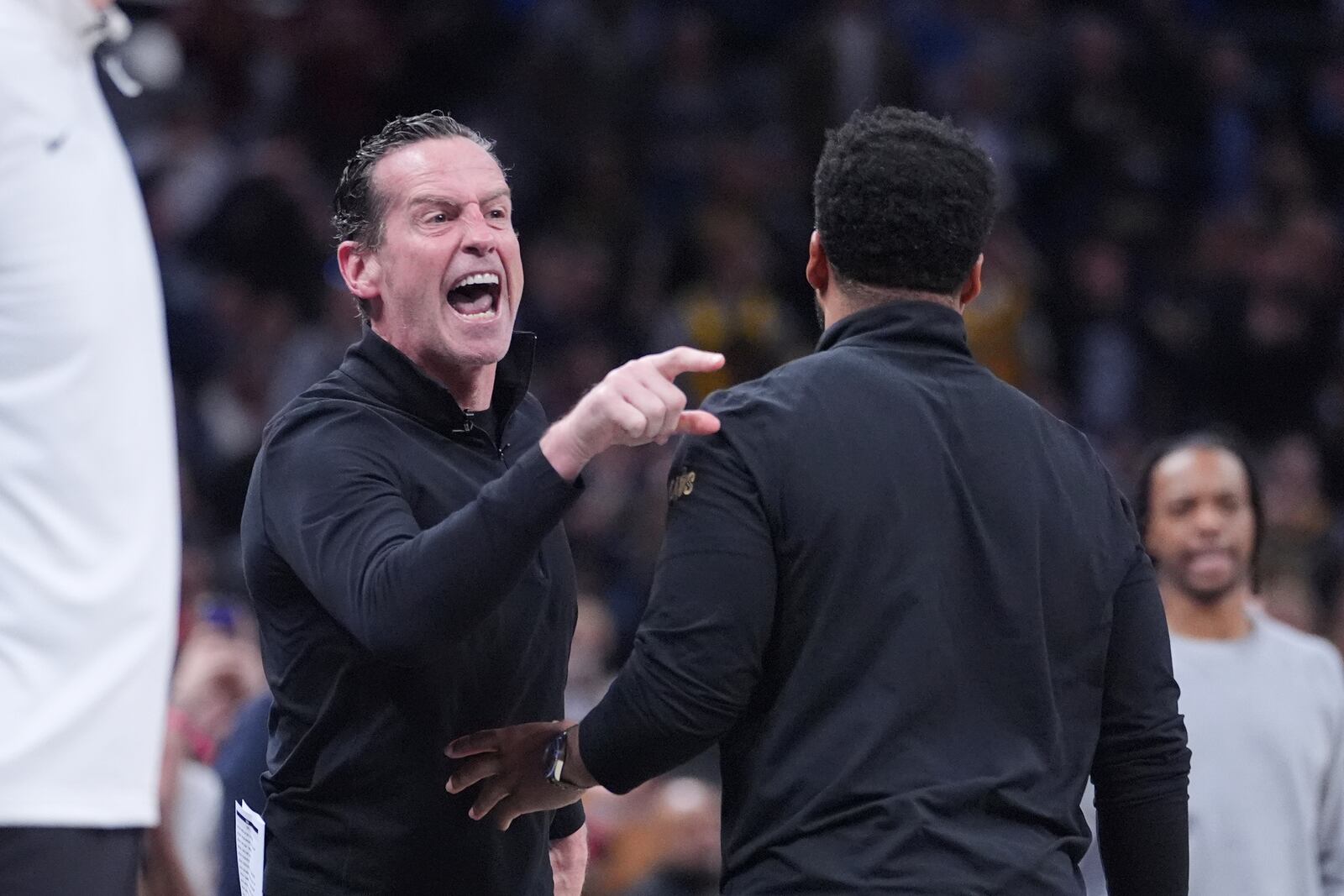 Cleveland Cavaliers head coach Kenny Atkinson, left, is held by associate head coach Johnnie Bryant after receiving his second technical and being ejected during the second half of an NBA basketball game against the Indiana Pacers in Indianapolis, Thursday, April 10, 2025. (AP Photo/Michael Conroy)