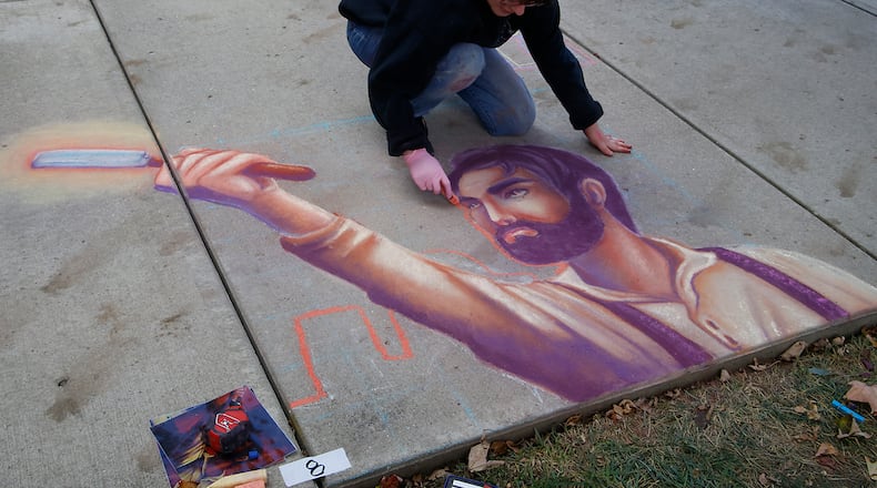 Savanah Holt works on his sidewalk art during ChalkFest 2023 at National Road Commons Park Saturday, Oct. 7, 2023. BILL LACKEY/STAFF