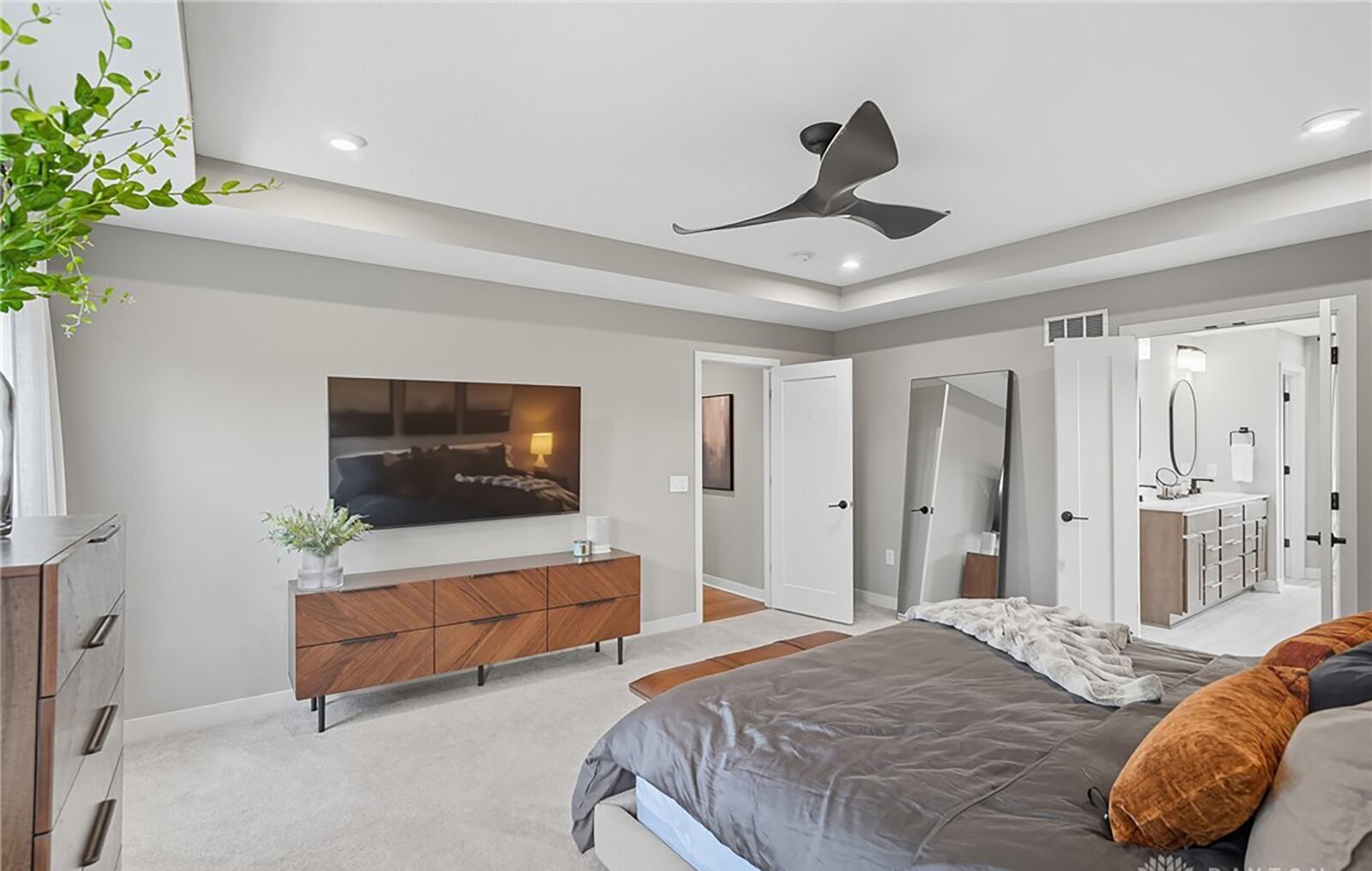 The primary bedroom suite has neutral carpeting, a tray ceiling, recessed lighting and a ceiling fan. It also has an ensuite bathroom. CONTRIBUTED