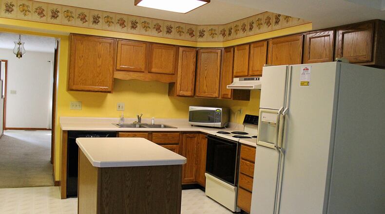 The kitchen boasts a movable island and plenty of wood cabinetry.