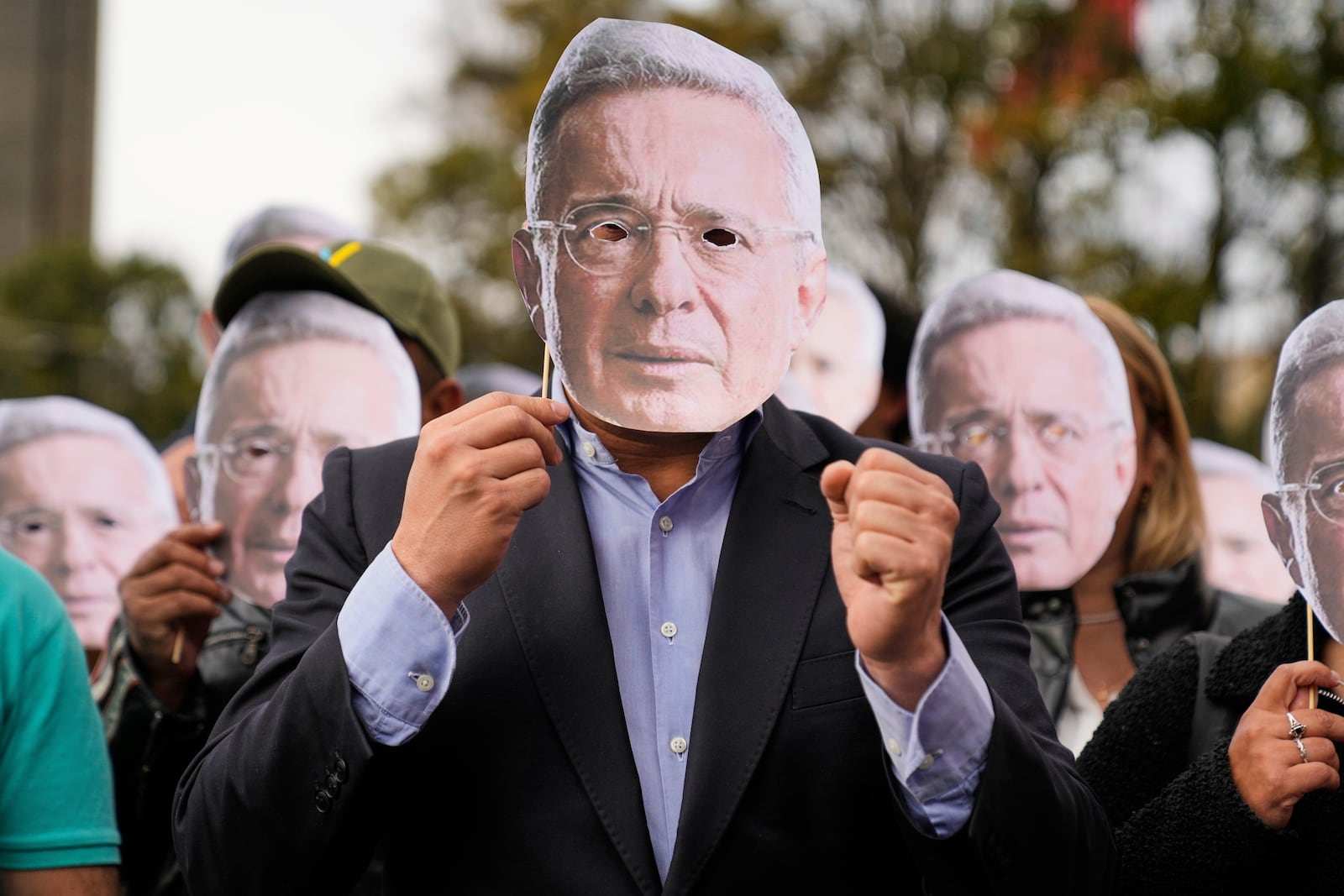 Supporters of former Colombian President Alvaro Uribe hold cutouts of his face outside the court where a verdict is expected in his trial for witness tampering in Bogota, Colombia, Monday, July 28, 2025. (AP Photo/Fernando Vergara)