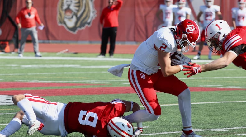 Wittenberg's Max Yost, left, and Anthony Pedro, right, tackle Denison's DJ Johnson on Saturday, Oct. 22, 2022, at Edwards-Maurer Field in Springfield. David Jablonski/Staff