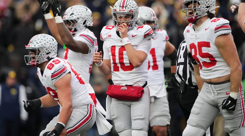 Ohio State quarterback Julian Sayin, center, celebrates near tight ends Will Kacmarek, left, and Bennett Christian after scoring a touchdown during the first half of an NCAA college football game against Michigan, Saturday, Nov. 29, 2025, in Ann Arbor, Mich. (AP Photo/Ryan Sun)