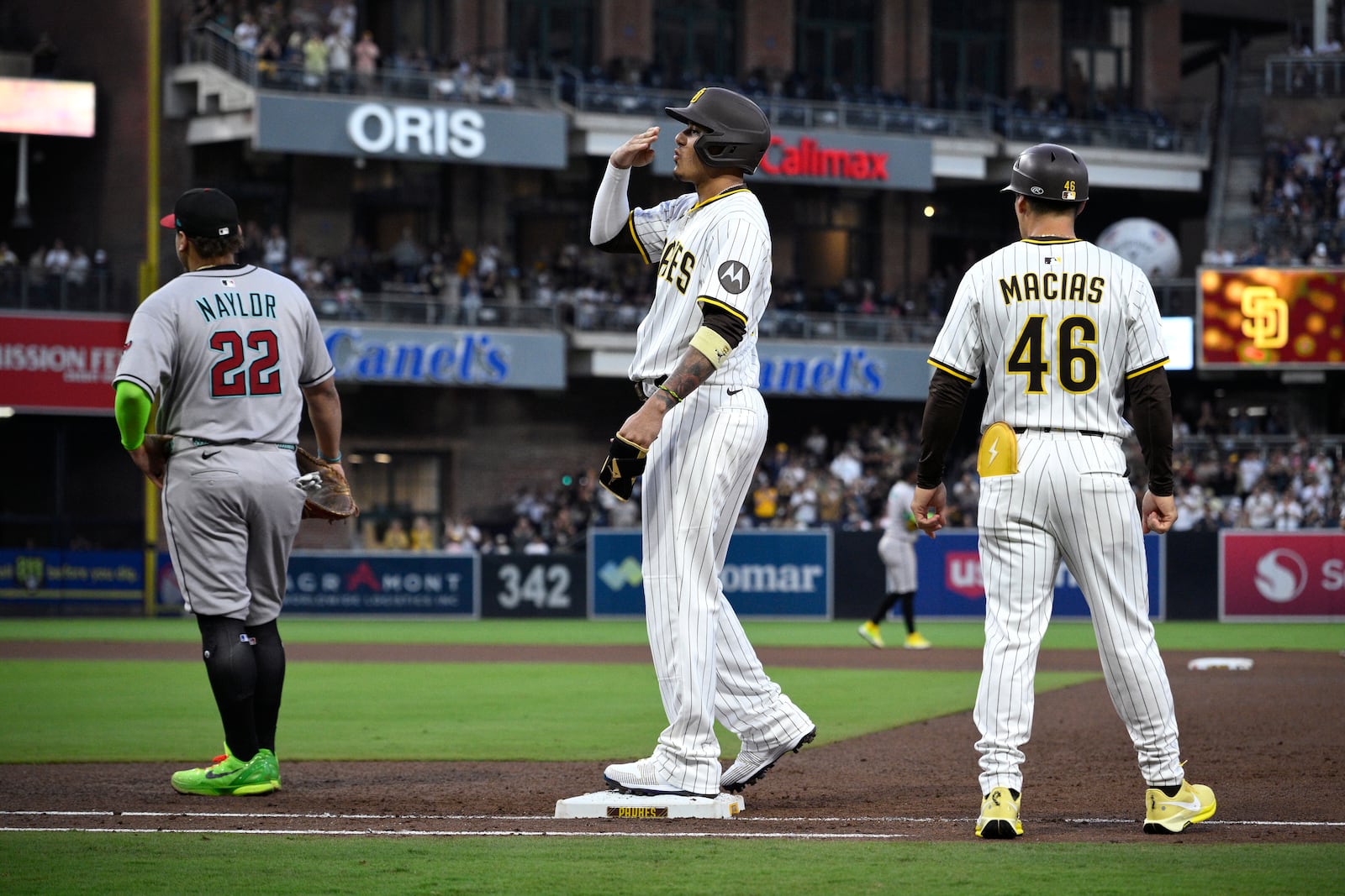 San Diego Padres' Manny Machado, center, reacts after hitting a single, his 2000th career hit, during the fourth inning of a baseball game against the Arizona Diamondbacks, Monday, July 7, 2025, in San Diego. (AP Photo/Orlando Ramirez)