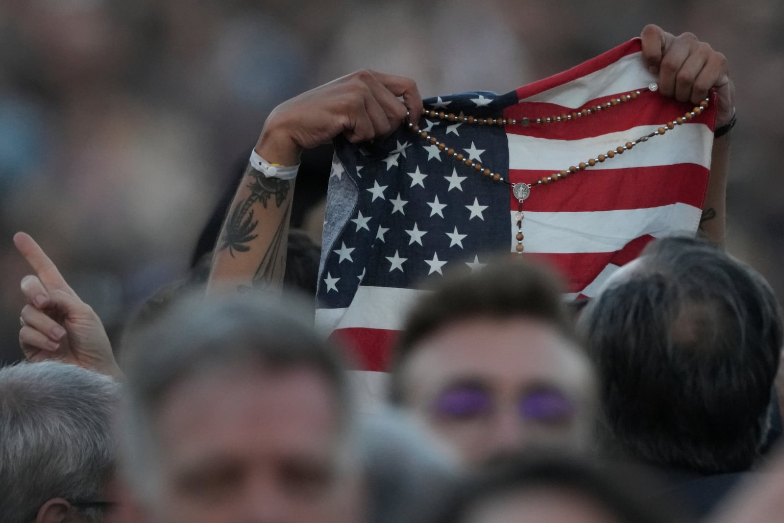 Faithful holds an American flag following the election of Pope Leo XIV at the Vatican, Thursday, May 8, 2025. (AP Photo/Andrew Medichini)