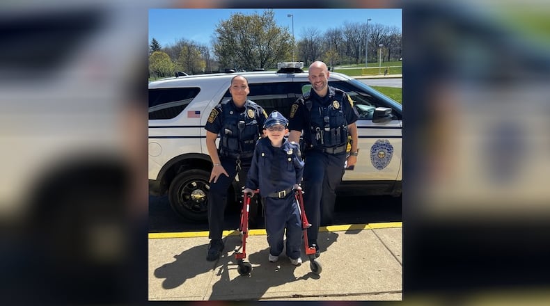 Officer Amanda Jackson (left) and Officer Adam Schaefer (right), two School Resource Officers for the Springfield City School District, “answered the call of duty” to provide Fulton Elementary School student Jonathan Beale with an honorary “SPD Police Officer” experience. Contributed
