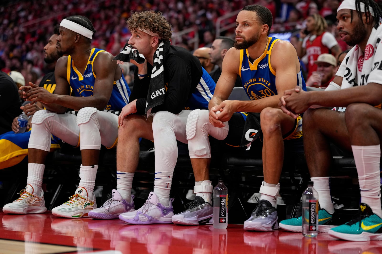 From left; Golden State Warriors forward Jimmy Butler III, guard Brandin Podziemski and guard Stephen Curry (30) sit on the bench during the second half of Game 5 of an NBA basketball first-round playoff series against the Houston Rockets, Wednesday, April 30, 2025, in Houston. (AP Photo/David J. Phillip)