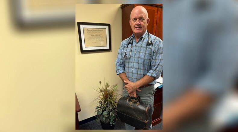 Dr. Barry Taylor opened his concierge medical practice in Dayton in 2012. He followed in his father (Charles Taylor) footsteps and became a doctor but wanted to do something different and more patient centered. He is shown holding his dad's medical bag. CONTRIBUTED