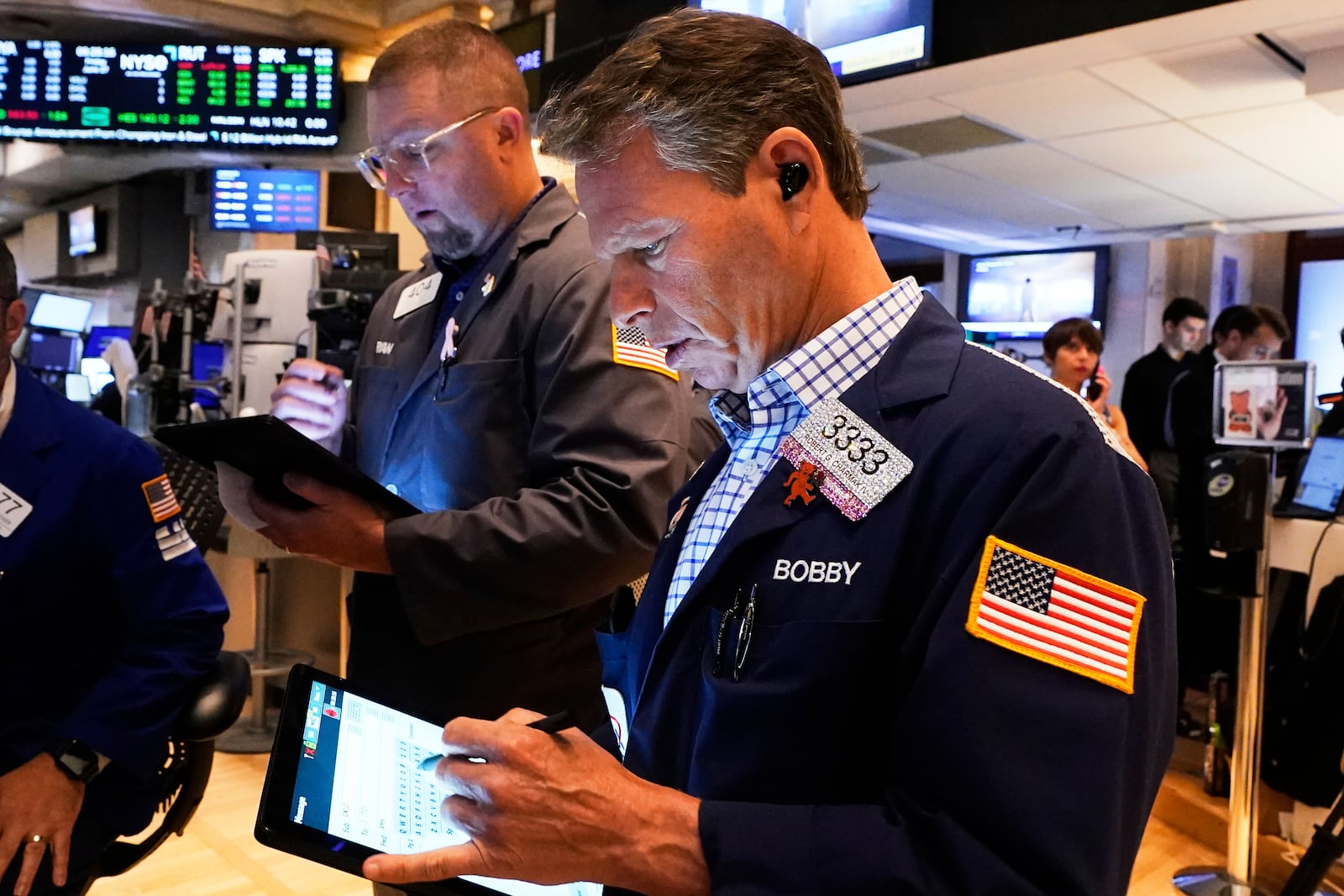 Traders Ryan Falvey, left, and Robert Charmak work on the floor of the New York Stock Exchange, Friday, June 27, 2025. (AP Photo/Richard Drew)