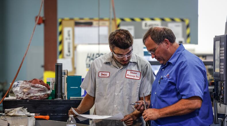 Machinist Dominic Davis, left gets instructions from Detailed Machining President and CEO, John Bertsch at the shop in Sydney Ohio. Bertsch is a hands on leader who works side by side with his employees.  JIM NOELKER/STAFF