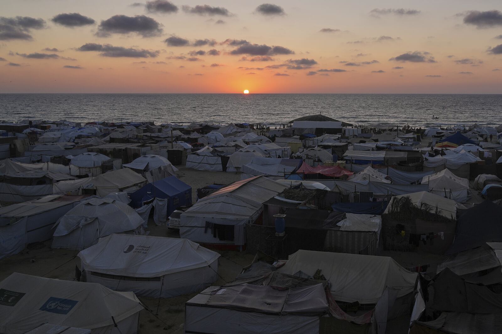 A tent camp for displaced Palestinians stretches near the shore during the sunset in Khan Younis, Gaza Strip, Wednesday, July 2, 2025. (AP Photo/Abdel Kareem Hana)