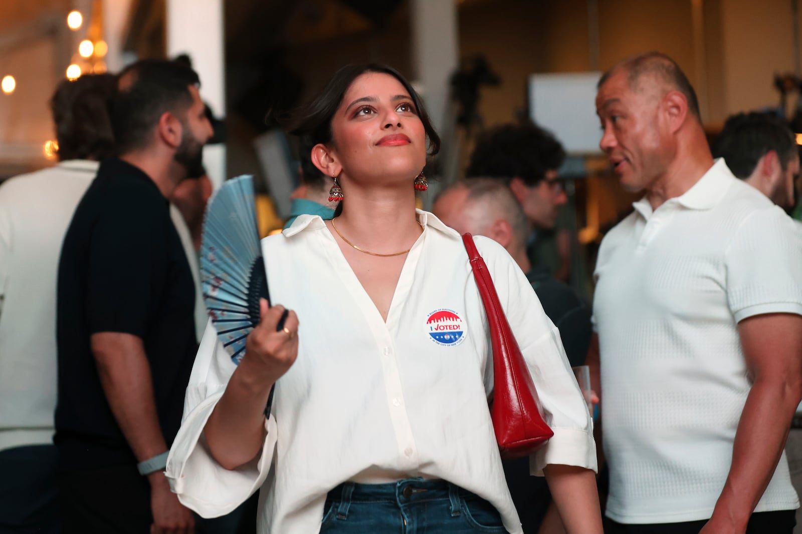 Supporters of Democratic mayoral candidate Zohran Mamdani fan themselves to keep cool as they watch results come in at his primary election party, Tuesday, June 24, 2025, in New York. (AP Photo/Heather Khalifa)