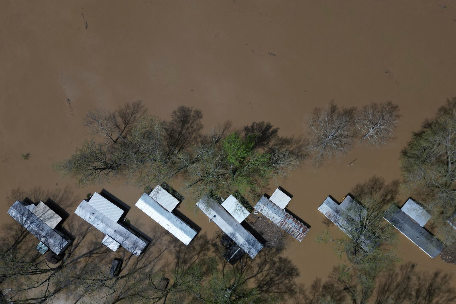 A mobile home park floods where rising waters of the Little Sugar Creek meet the Ohio River, Monday, April 7, 2025, in Napoleon, Ky. (AP Photo/Carolyn Kaster)