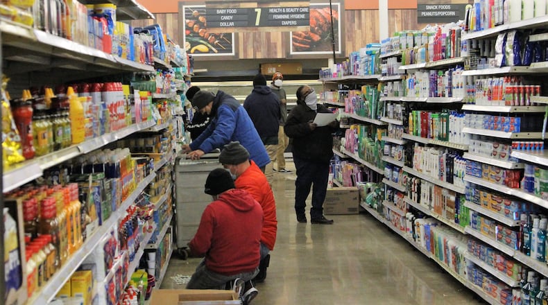 Cashiers and other employees at Groceryland prepare the store on Wednesday for its opening the following day. The grocery is located at the former Kroger building on South Limestone Street. Hasan Karim/Staff