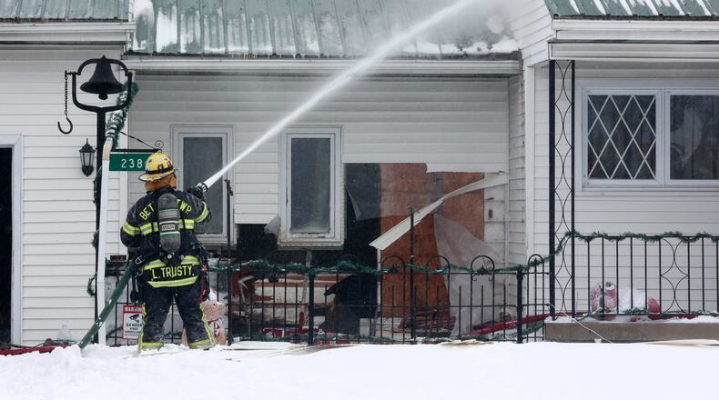 Firefighters from Bethel Township and several area departments battle a house fire in the 200 block of Green Acres Drive Friday afternoon. BILL LACKEY/STAFF