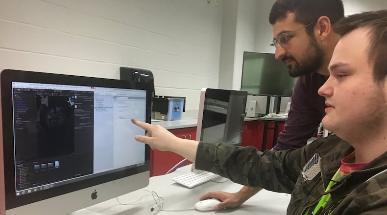 Consultant David Hazlett and Springfield High School senior Isaac Buzard look at a video game Buzard is designing in a video game class at the high school.
