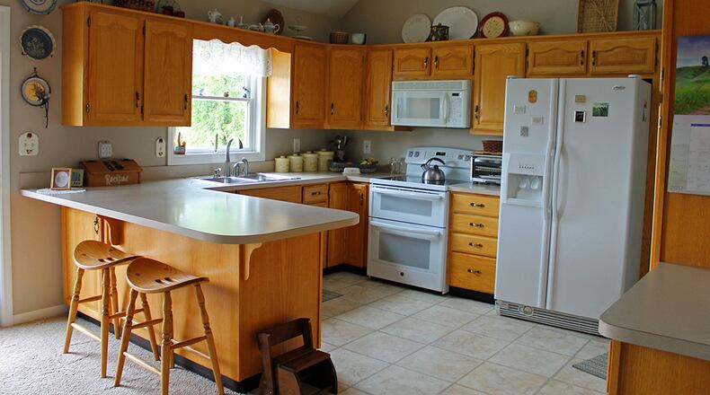 The kitchen includes a breakfast bar and plenty of counter space. French doors open to the backyard and rear deck.