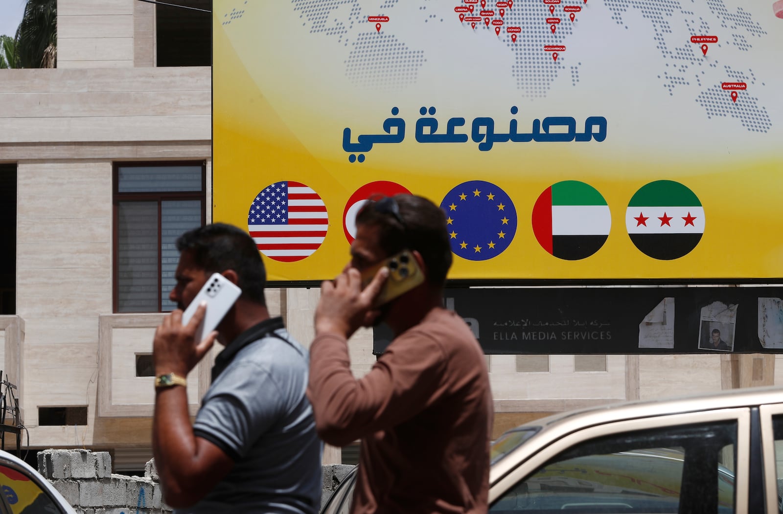 Syrian men speak on their phones on a street in Damascus, Syria, Wednesday, May 14, 2025. (AP Photo/Omar Sanadiki)