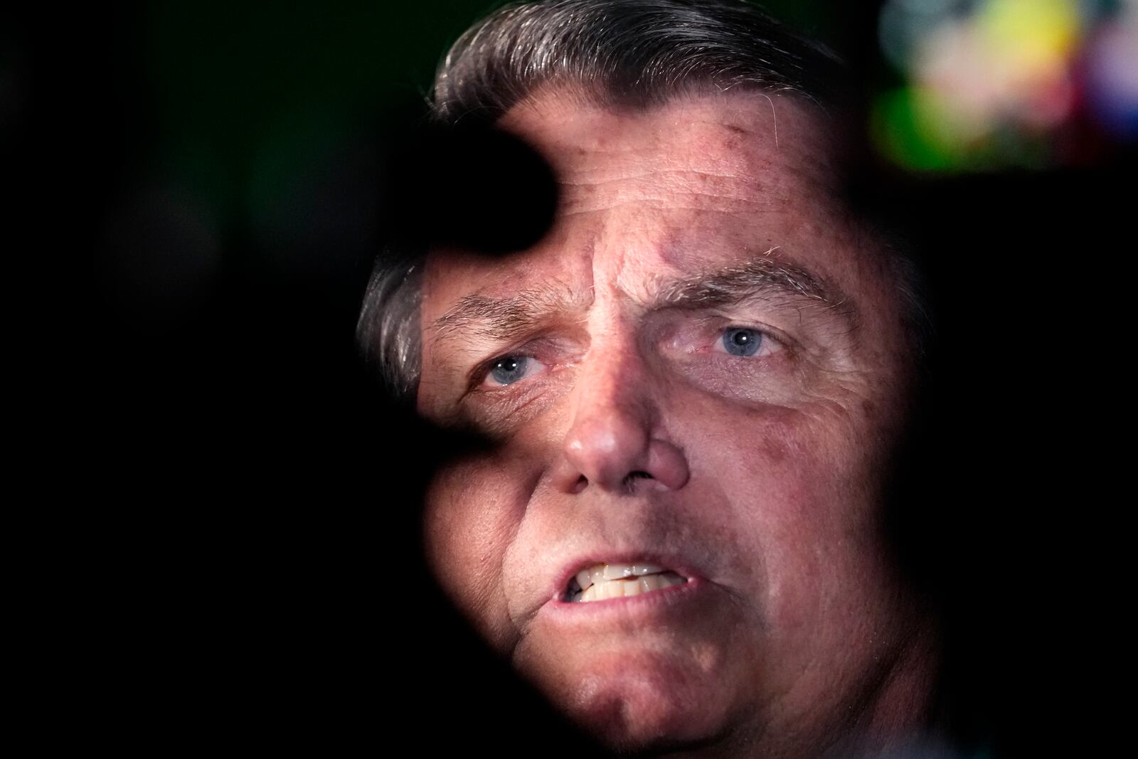 FILE - Former President Jair Bolsonaro talks to reporters after arriving at the airport in Brasilia, Brazil, June 30, 2023. Bolsonaro was barred from running for office again until 2030 after a panel of judges concluded that he abused his power and cast unfounded doubts on the country's electronic voting system. (AP Photo/Eraldo Peres, File)